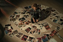 Detective Liz Danvers in True Detective looks at splayed out pictures of crime scenes