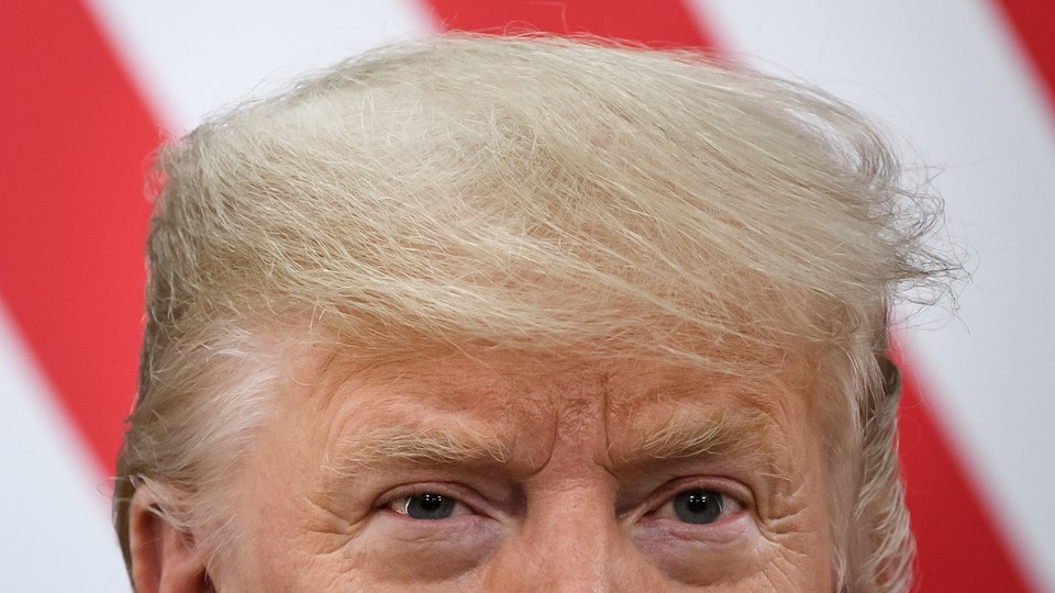 Top half of President Donald Trump's head in front of red and white stripes of the American flag