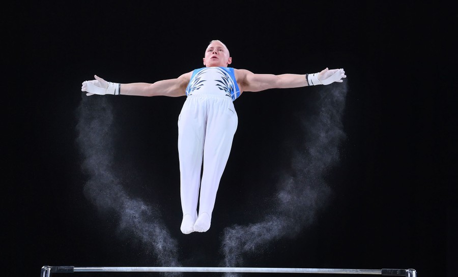 A gymnast flies through the air after a release during a competition.