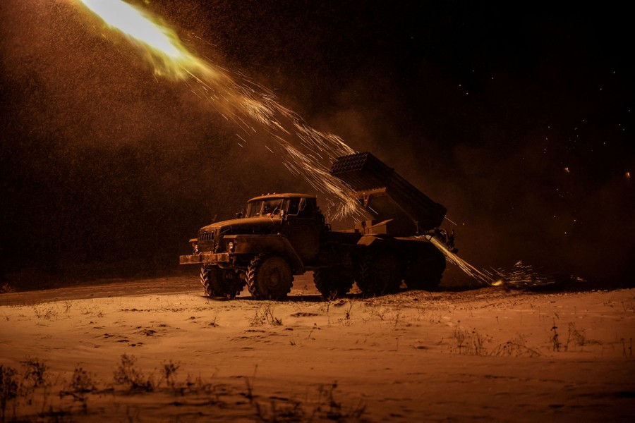 Sparks fly as a missile launches from an apparatus attached to the back of a truck that is parked in a field.
