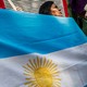 Photograph of a woman holding an Argentinian flag