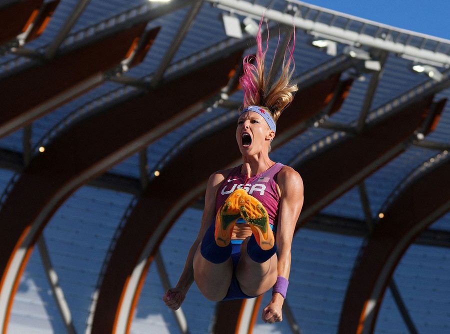 An athlete shouts as she falls from a pole-vault jump.