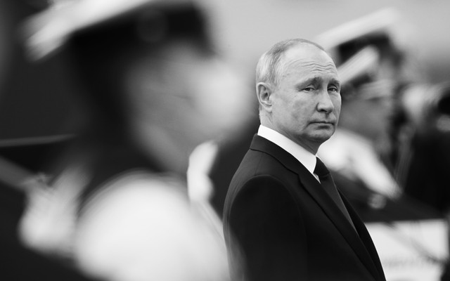Vladimir Putin looks out from a crowd.