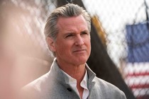 Photo of Gavin Newsom in front of a fence.
