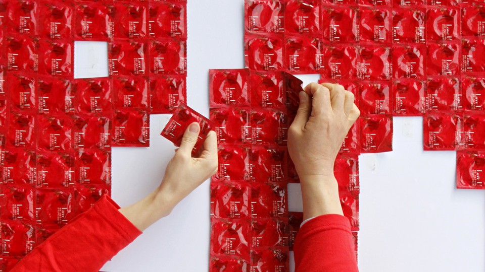 Hands are shown taking condoms from a pile.