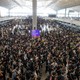 Protesters wearing black T-shirts crowd the departures hall of Hong Kong's international airport.