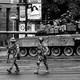 A black-and-white image shoes Wagner mercenaries walking next to a tank on a street in Rostov-on-Don.
