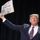 Trump displays a newspaper reading, "Acquitted"
