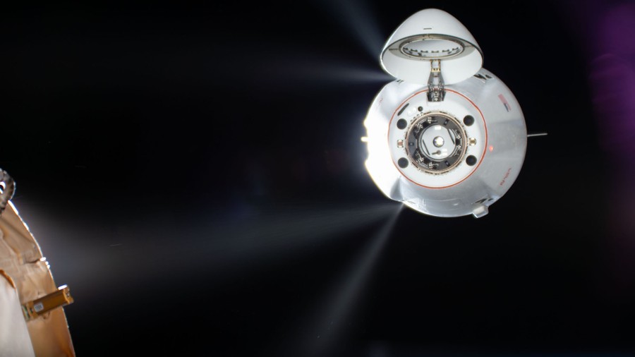 A small spacecraft fires thrusters as it nears the ISS.