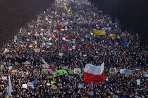A huge crowd of protesters holding up Ukrainian and Eastern European flags