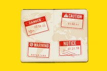 Four small warning signs in a passport that read "danger," "caution," "warning," and "notice"