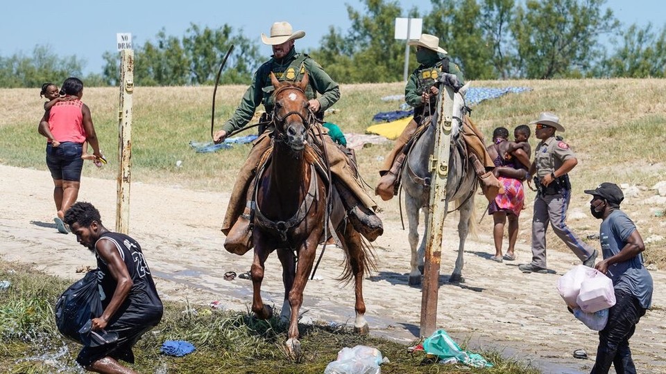 DHS agents with Haitian migrants at the border