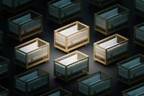 Several rows of empty cribs illuminated by stark lighting