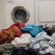 A pile of laundry in front of a washing machine