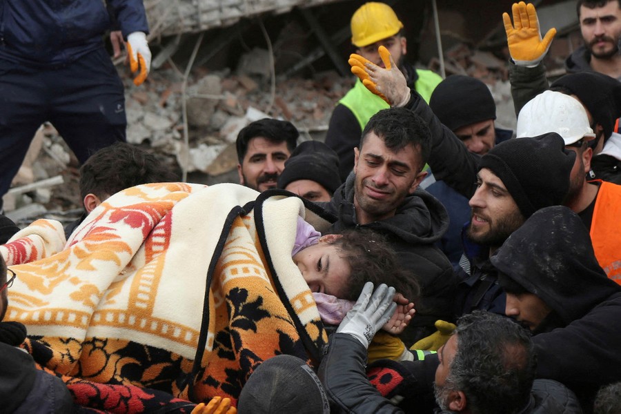 Rescuers carry a girl from a collapsed building.