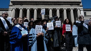 Photograph of a faculty protest at Columbia University in April, with professors holding up signs that say, "Hands off our students"