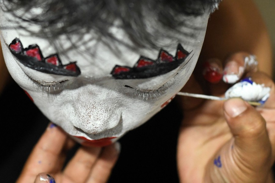 A boy has stage makeup applied to his face.