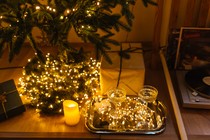 Vinyl record player next to a Christmas tree and lights