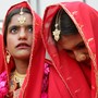 A young Pakistani bride in a sari looks up at the sky during a mass wedding ceremony in Karachi.
