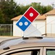 A delivery vehicle with a Domino's logo on top