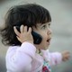 a small girl talking on a phone