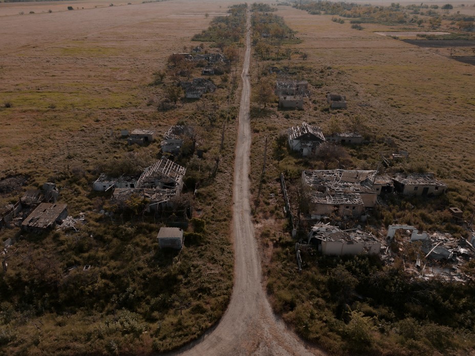 An aerial of a road with bombed out houses on either side.