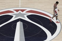 A Washington Wizards player walking across the court, head down