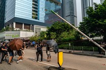 Protesters in Hong Kong take down a lamppost