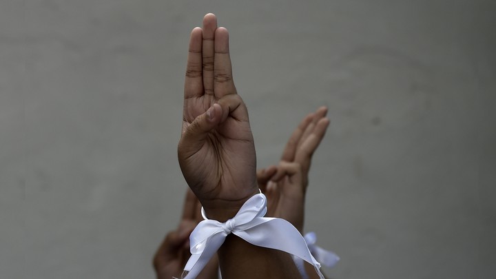 Hands raised with the three finger salute