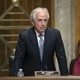 Senator Bob Corker of Tennessee stands in a hearing room.