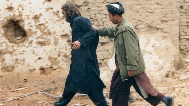 John Walker Lindh is escorted by a Northern Alliance fighter after his capture in Afghanistan in December 2001.