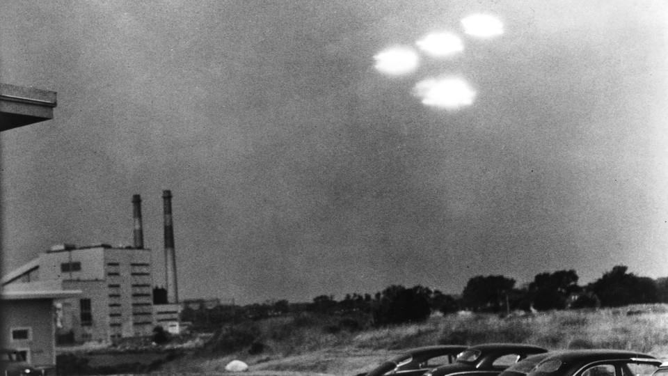 A cluster of glowing unidentified objects hovers in the sky over Salem, Massachusetts, in 1952.