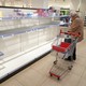 A woman shopping at a store with empty shelves