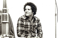 detail from black-and-white photo of Albert Brooks with film equipment on set