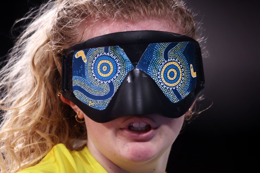 An athlete wears a mask over her eyes while playing goalball.