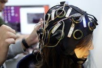 A woman wearing a brain-scanning helmet