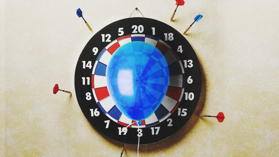 A dartboard with a balloon at the center and darts that have missed the target around the outside
