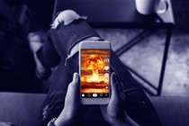 A phone screen showing a mushroom-cloud explosion