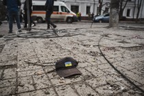 A cap with the Ukrainian flag and coat of arms on a city street