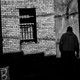 A shadowy figure walks through an alley