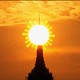 New York City's Empire State Building, with a coronavirus-shaped sun behind it