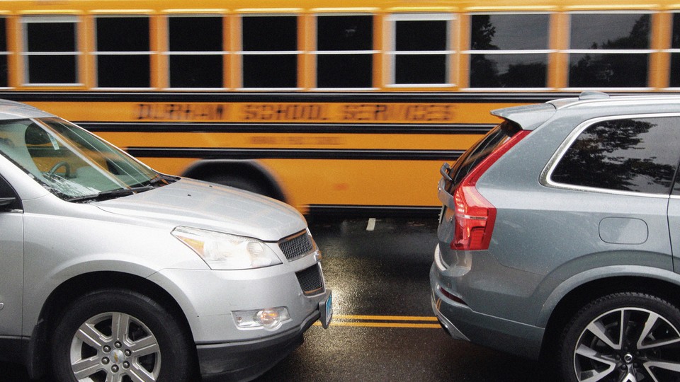 Two cars in front of a school bus