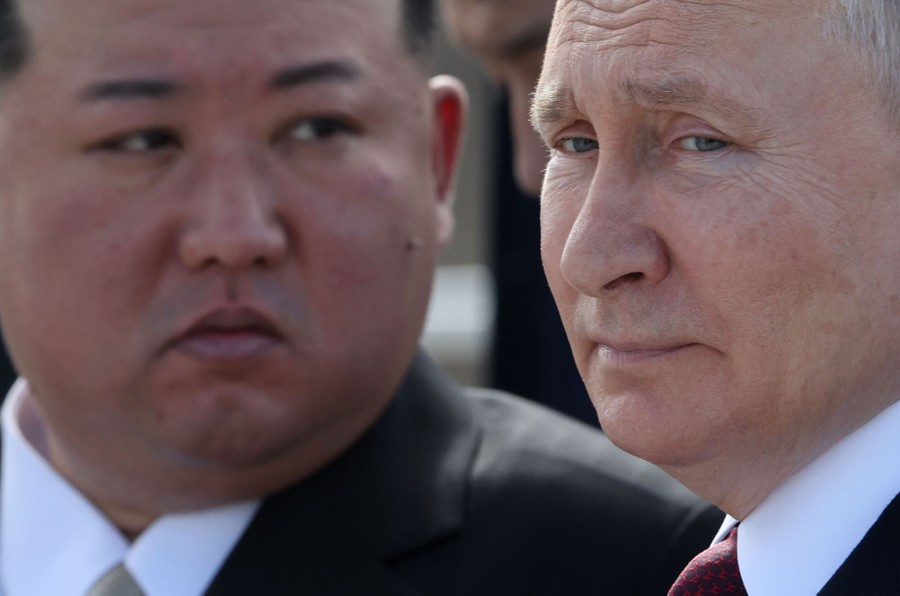 A close image of the faces of  Vladimir Putin and Kim Jong-un