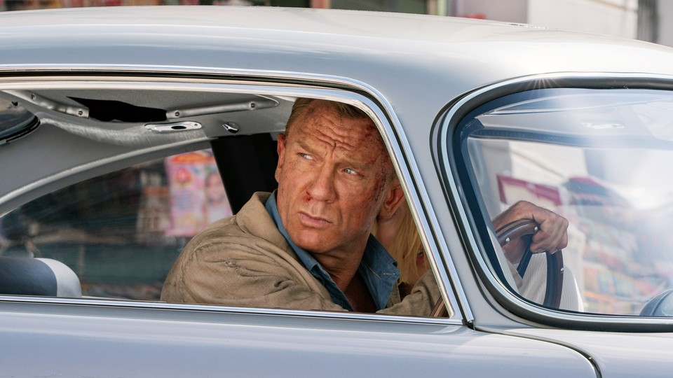 James Bond, played by Daniel Craig, looks out of the window of a car.