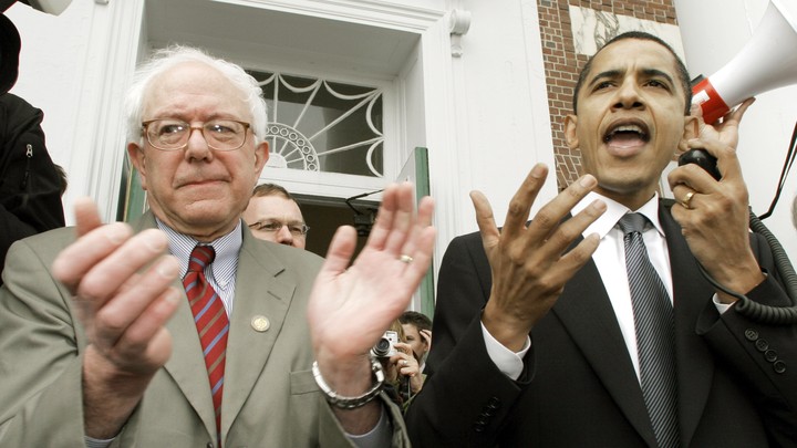 Barack Obama speaking at a Democratic rally in 2006 while Bernie Sanders claps beside him.