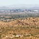 Phoenix, Arizona, from South Mountain Park on June 18, 2020. There are brown hills in the foreground, and the city's skyline in the background.