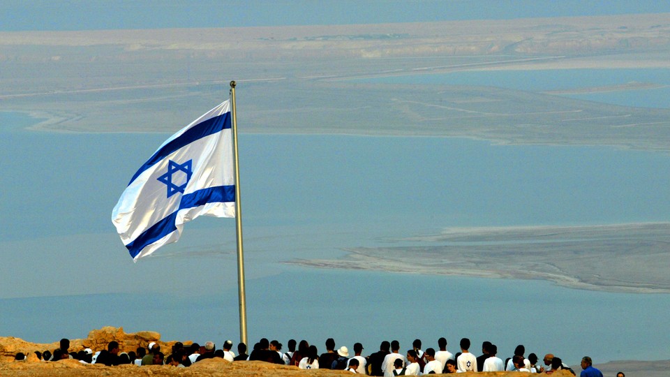 The Israeli flag flies on the ancient hill top fortress of Masada in the Judean desert