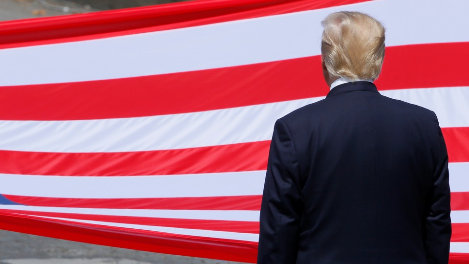 U.S. President Donald Trump stands in front of the American flag.