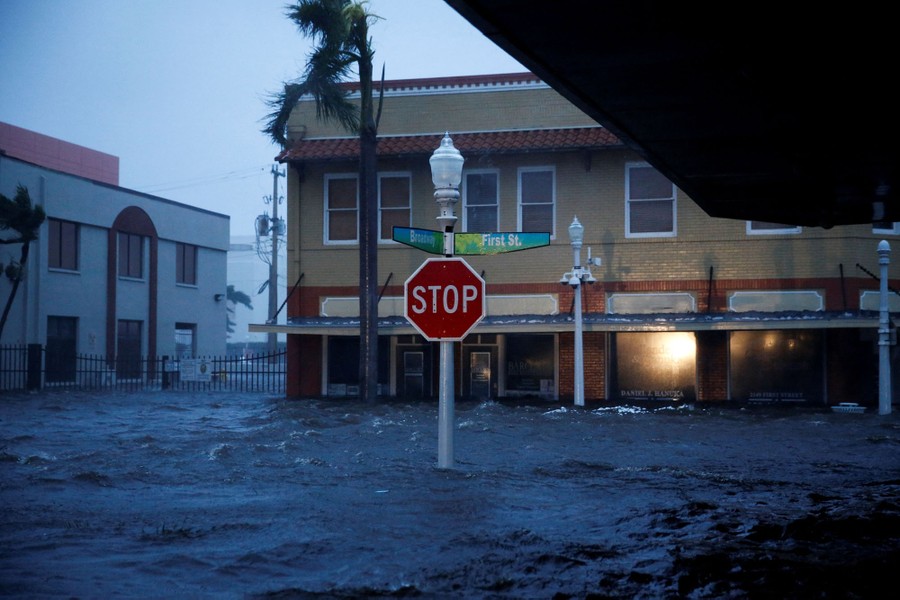 A flooded street, with a stop sign standing in the water.