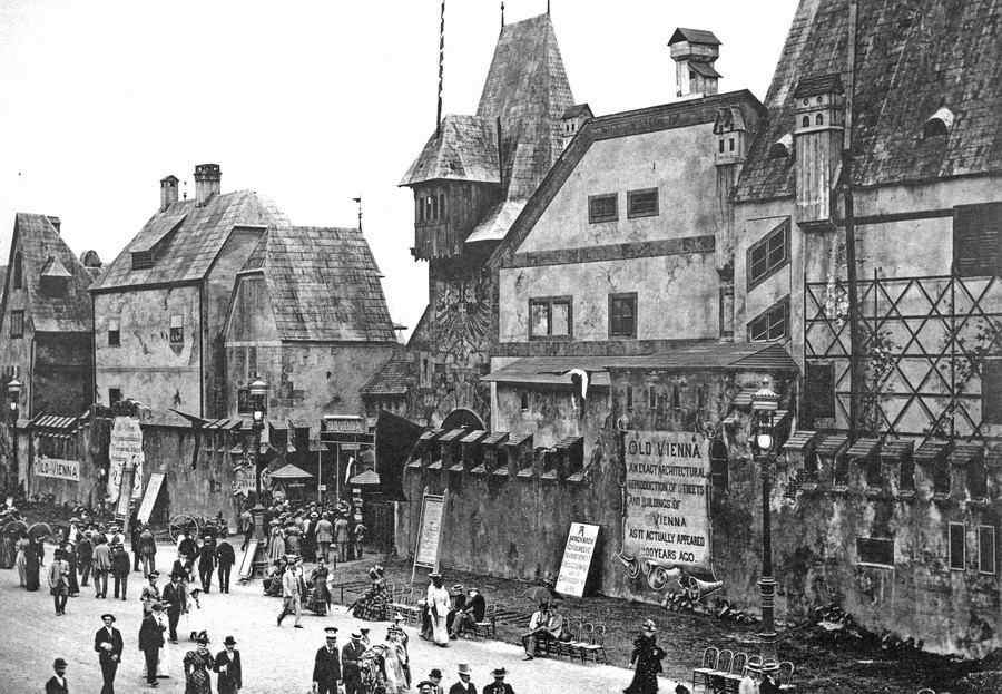 People walk past a fairground exhibit built to resemble Vienna in the 1600s.
